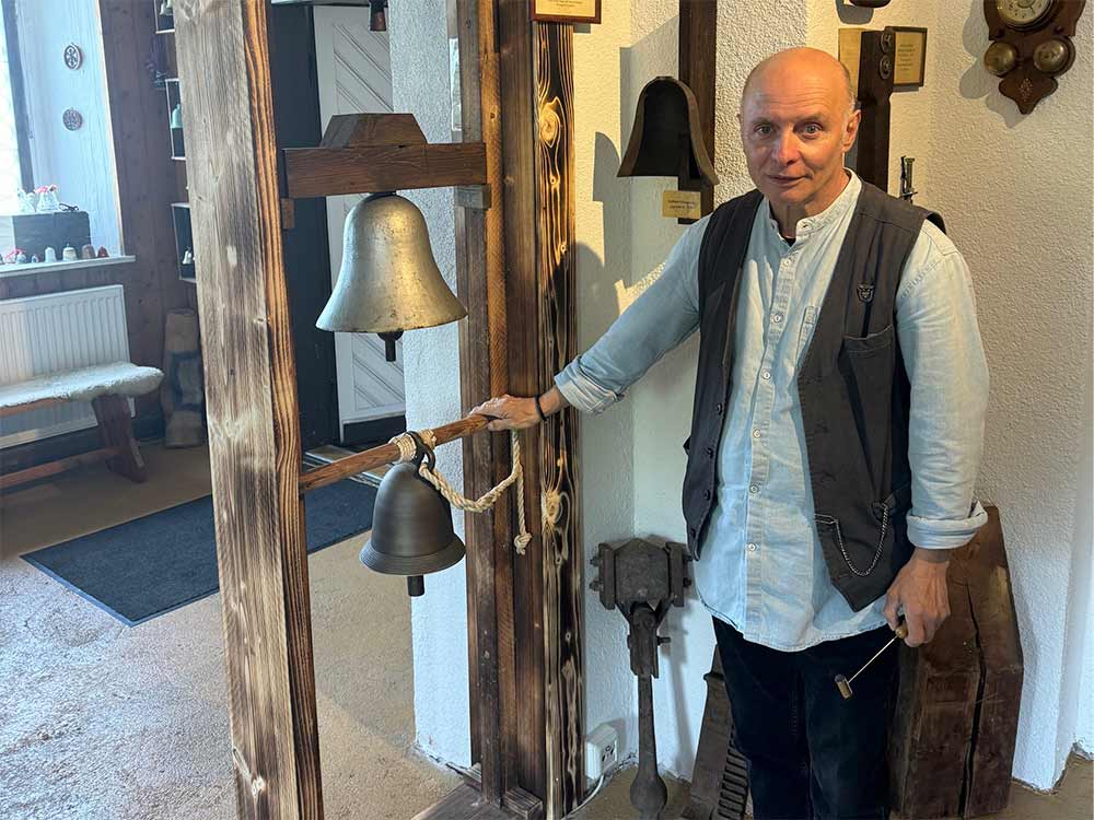 Gerd Schlesinger neben einem hölzernen Gestell mit Glocken